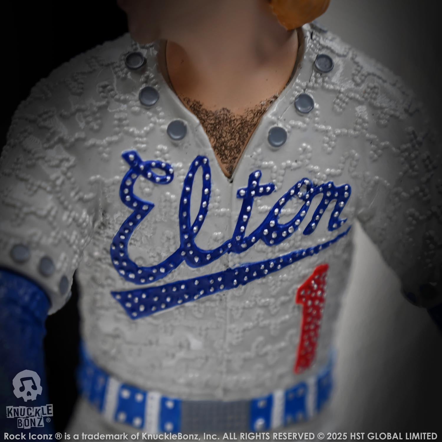 Elton John statue wearing a gray jersey with 'Elton' and number '1' on a dark background